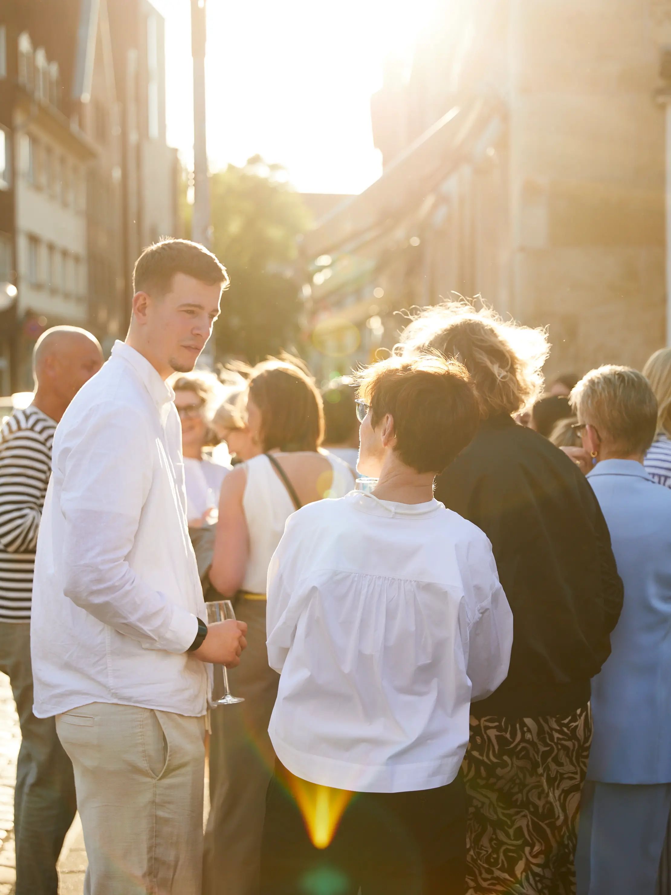 Gesellige Atmosphäre bei der Schnitzler-Feier zum TW Forum Preis 2025, Menschen im Austausch im Abendlicht. 