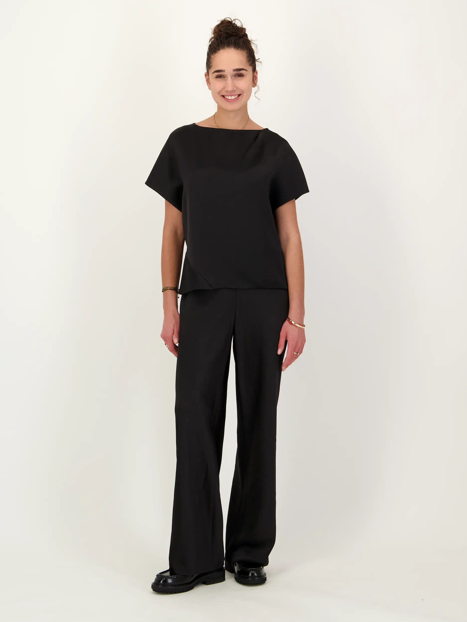 Satinbluse kurzarm - Artikel Teil eines Outfits getragen von einem Modell - Farbe: Schwarz