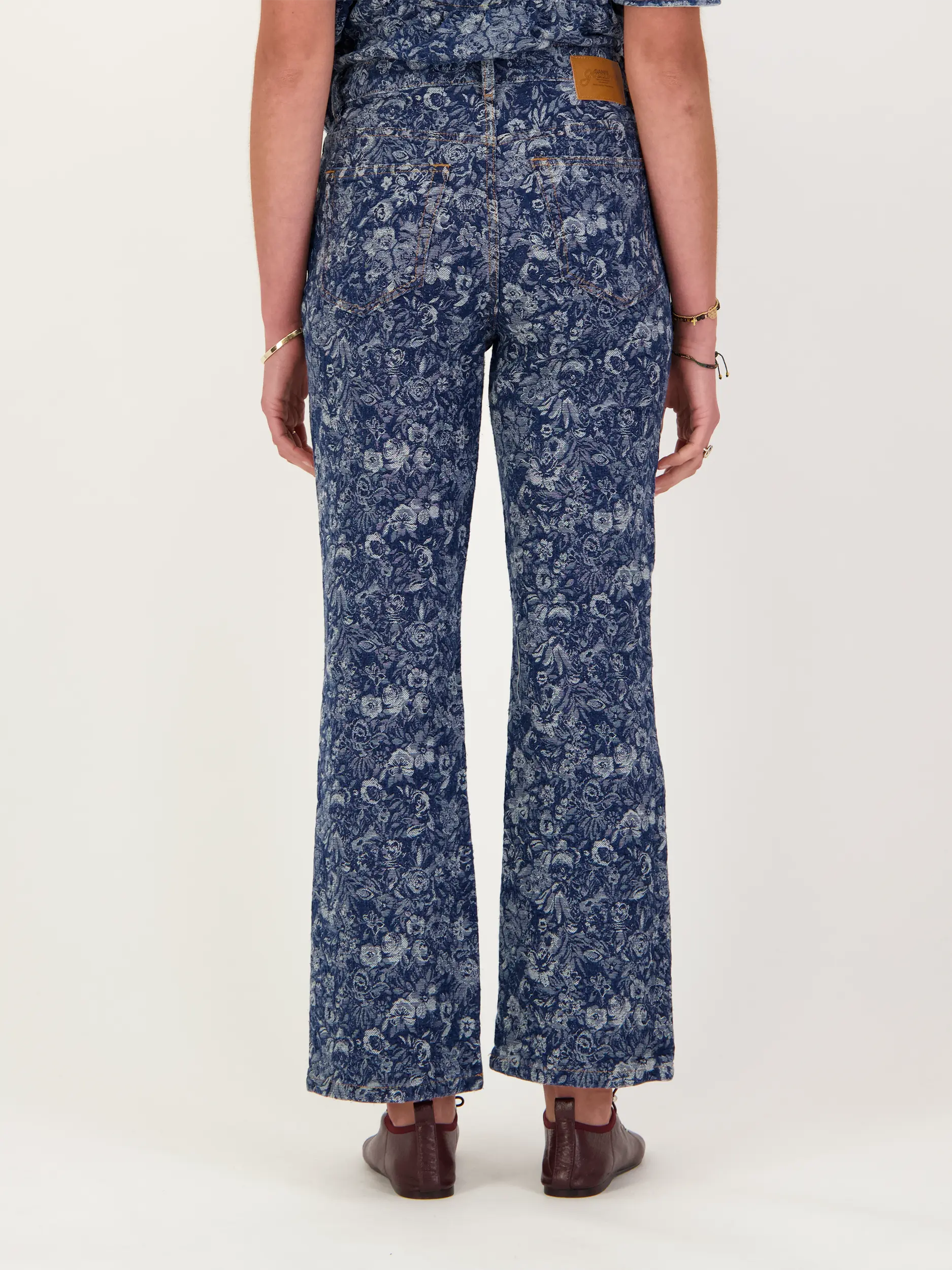 High Rise Bootcut Jeans mit Blumenprint - Artikel Rückseite getragen von einem Modell - Farbe: Blau