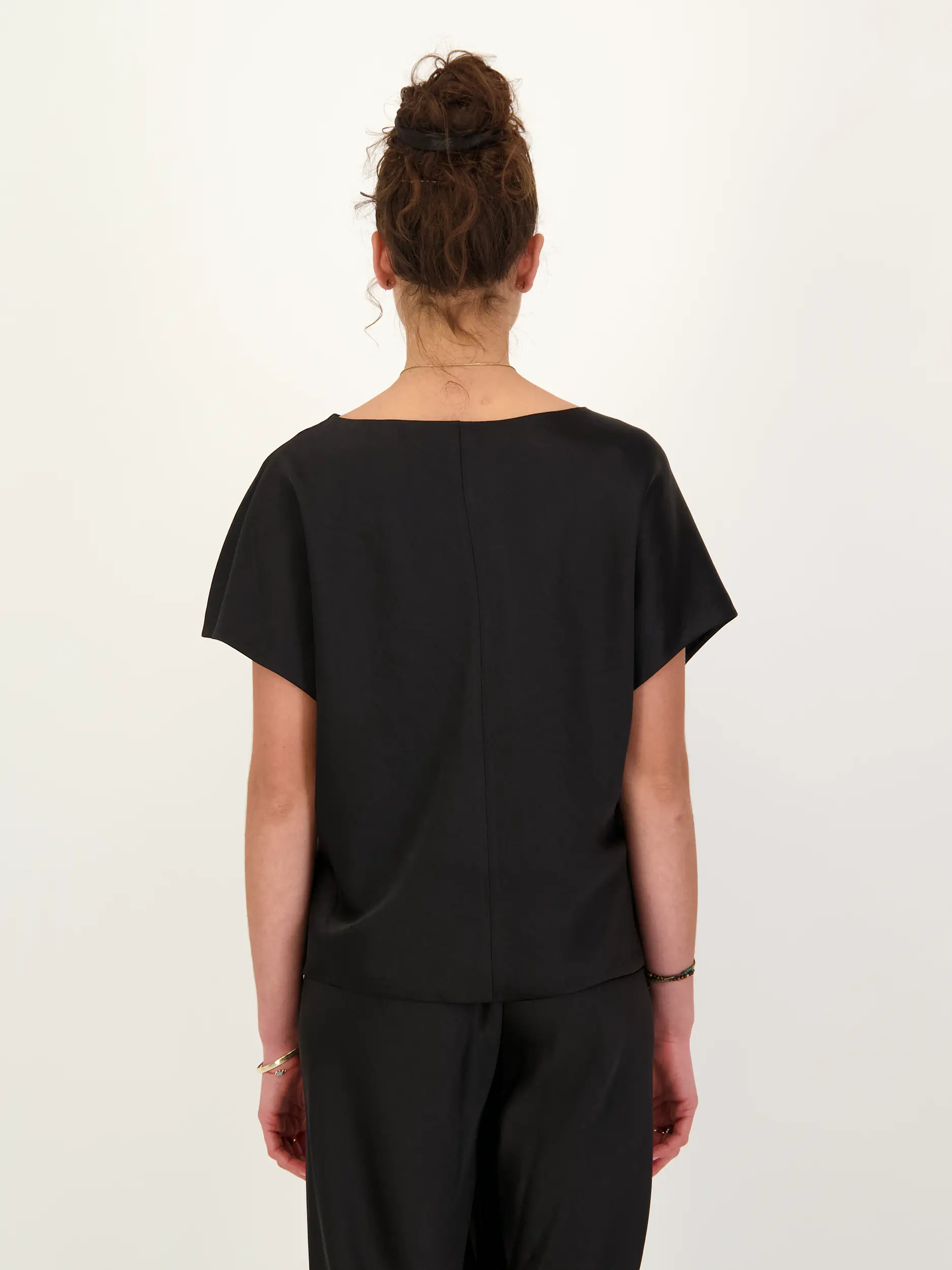 Satinbluse kurzarm - Artikel Rückseite getragen von einem Modell - Farbe: Schwarz