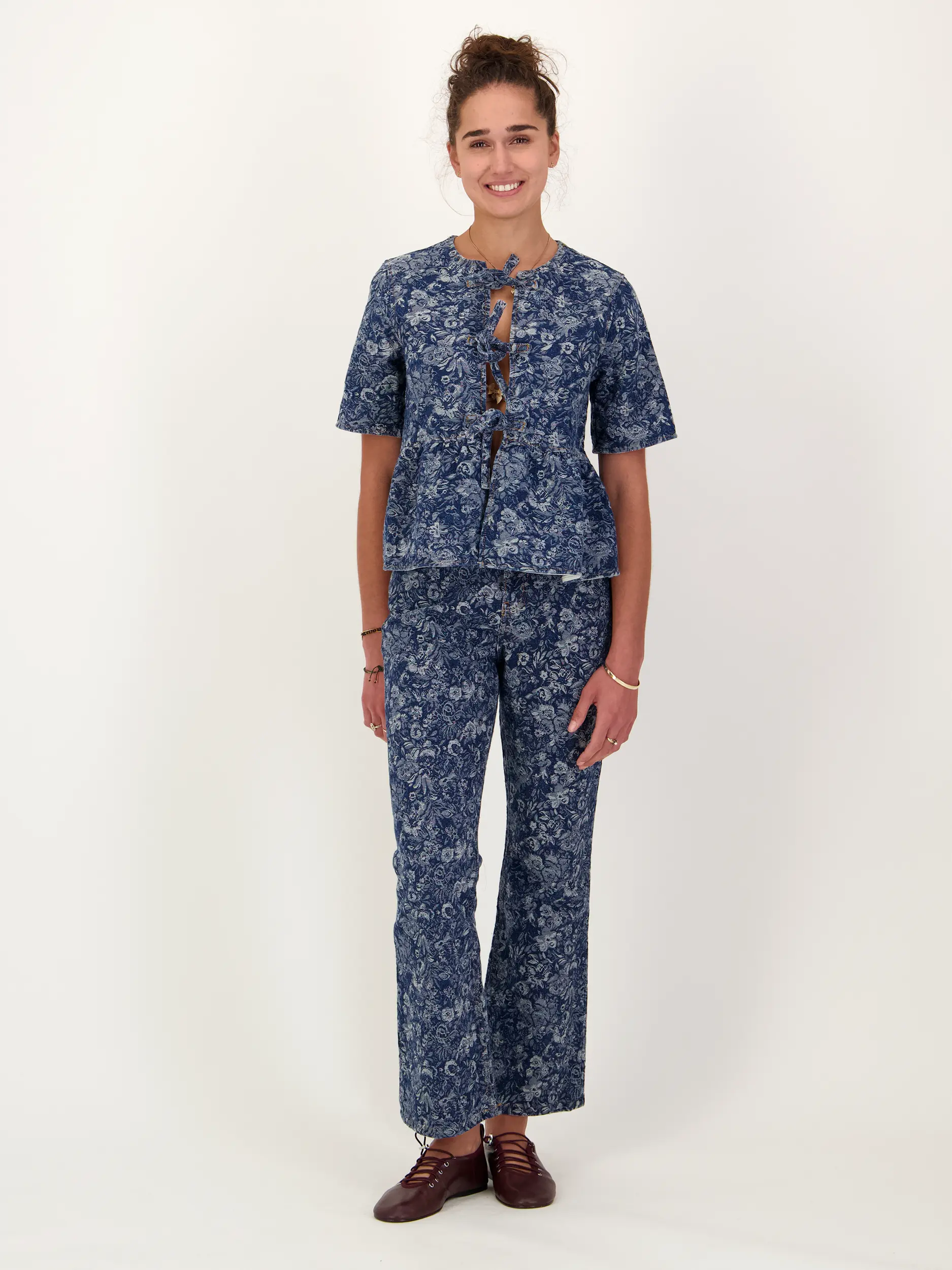 High Rise Bootcut Jeans mit Blumenprint - Artikel Teil eines Outfits getragen von einem Modell - Farbe: Blau