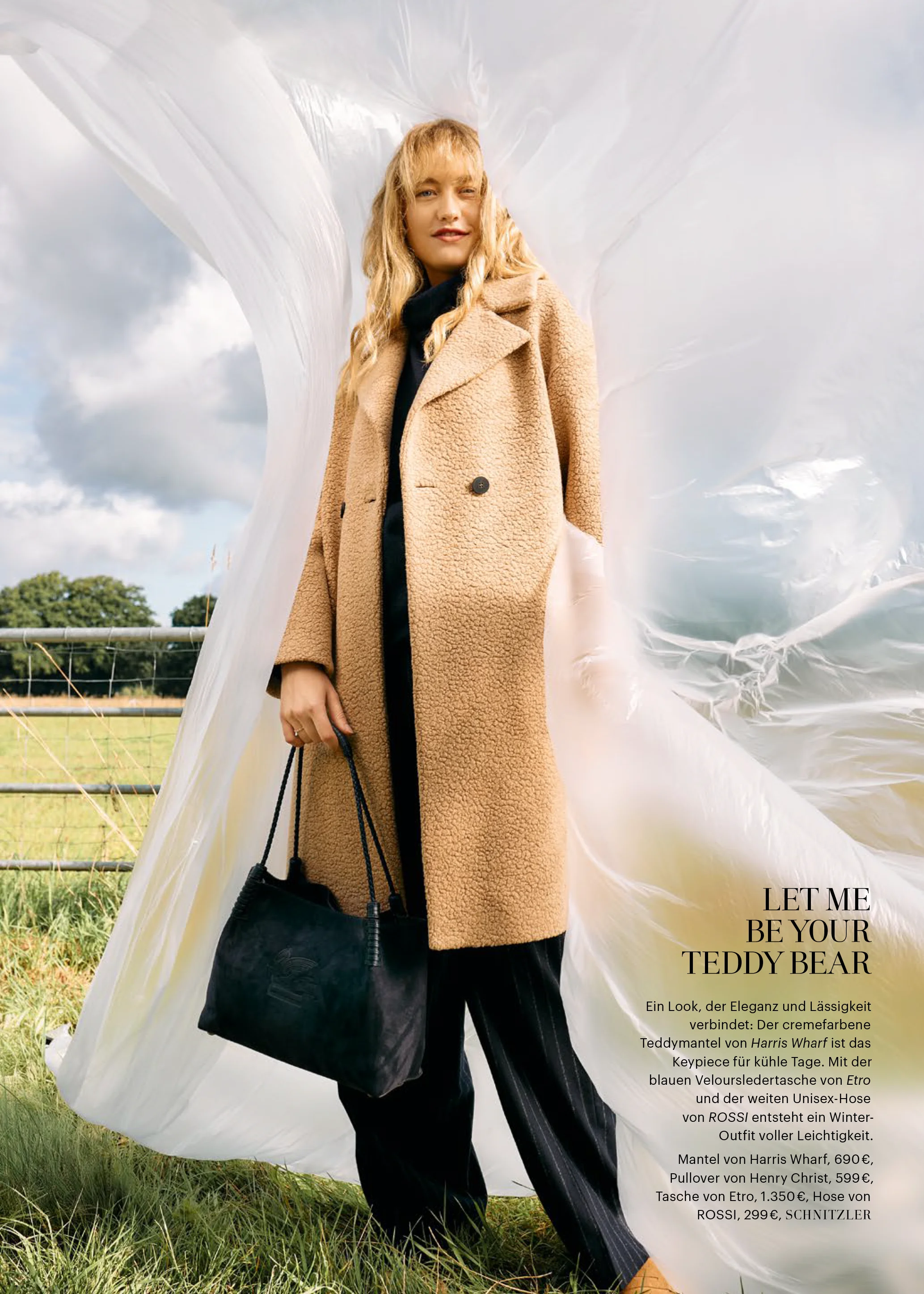 Das Bild zeigt unser Model in einem beigen Teddy Mantel und einer blau-weiß gestreiften Stoffhose.