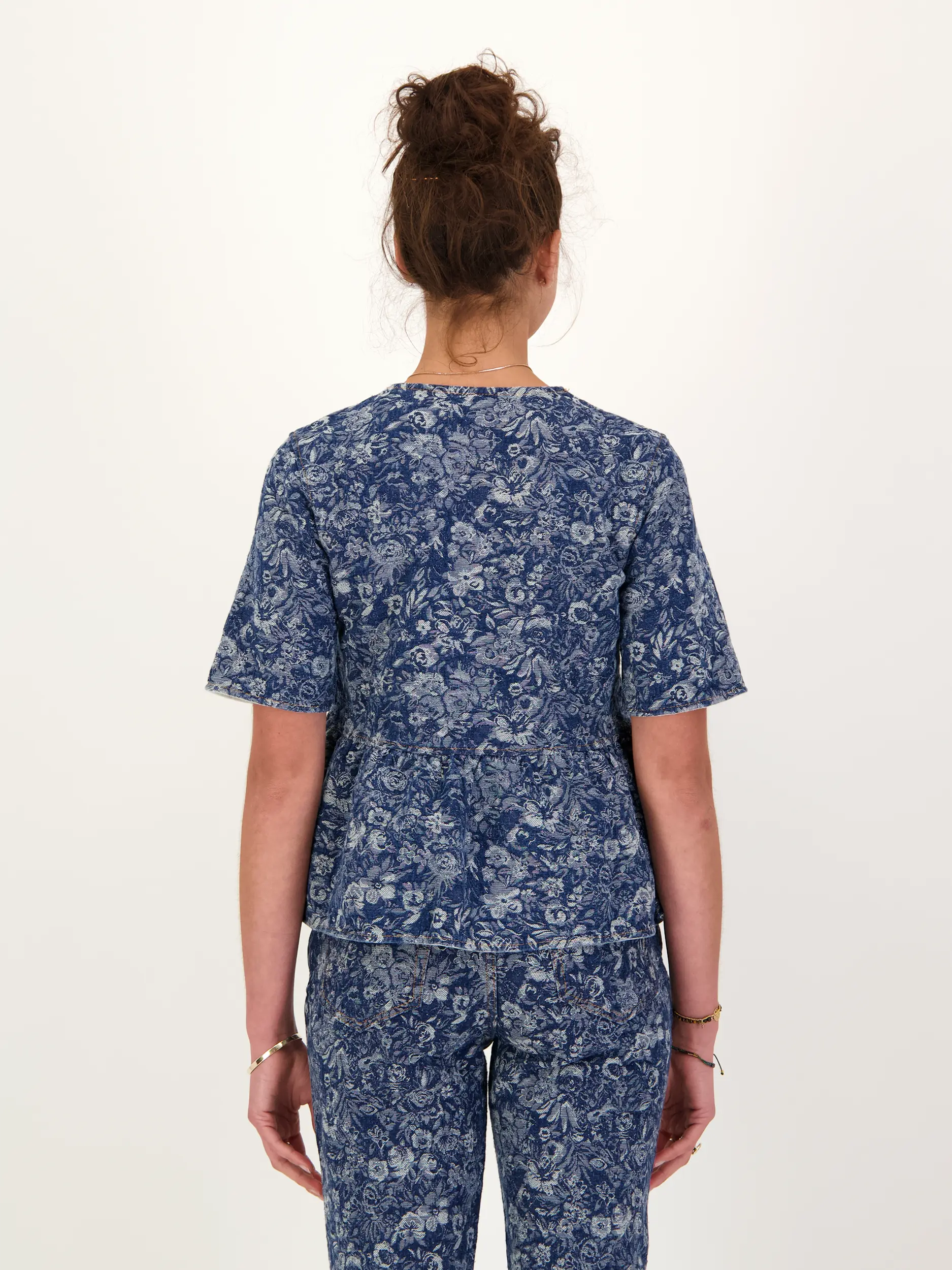 Jeansbluse mit Schleifen und Blumen Print kurzarm - Artikel Rückseite getragen von einem Modell - Farbe: Blau