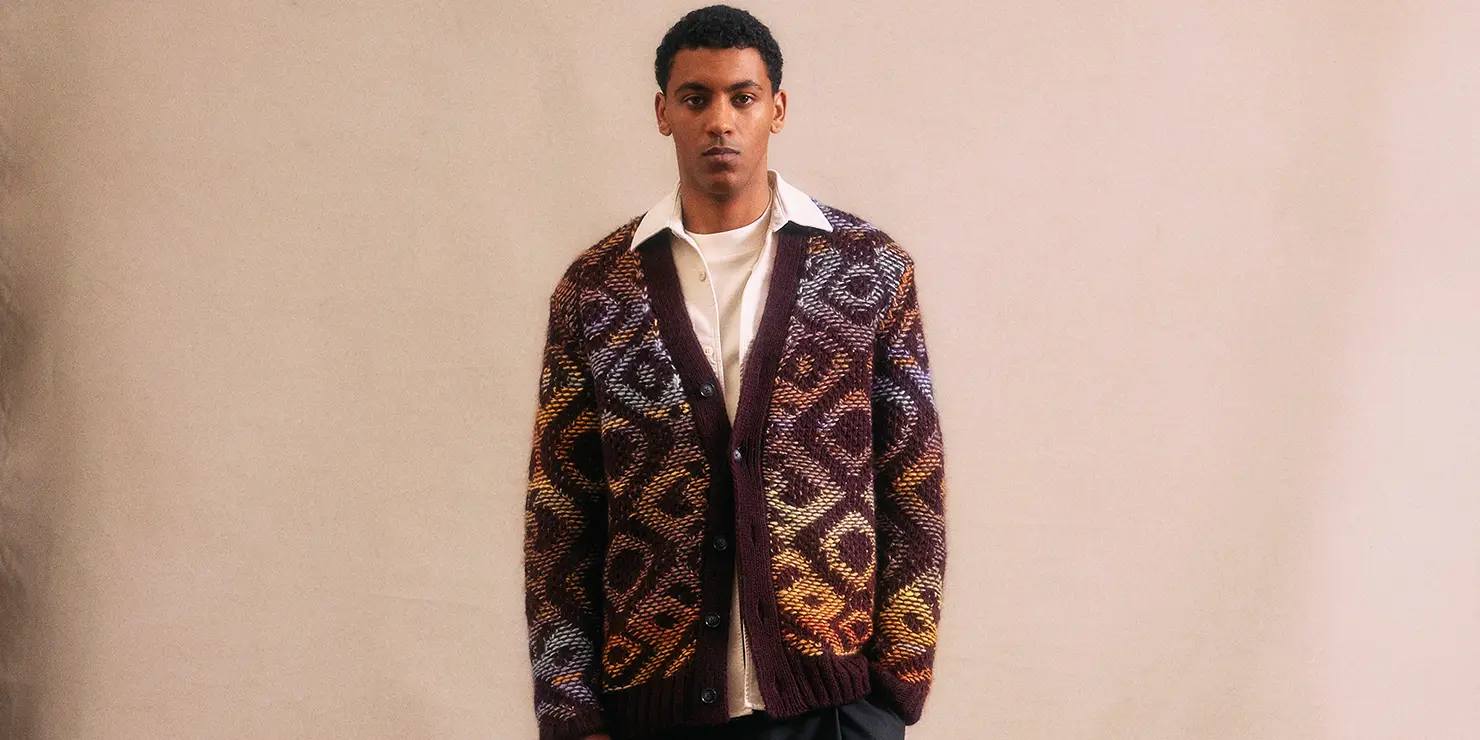 Das Bild zeigt einen Mann mit einer farbigen Strickjacke von NN07