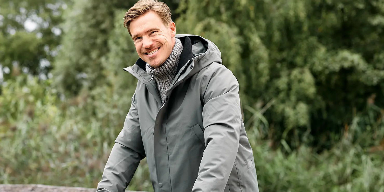 Das Bild zeigt unser Herrenmodel mit einer grün-grauen GOFRANCK Jacke